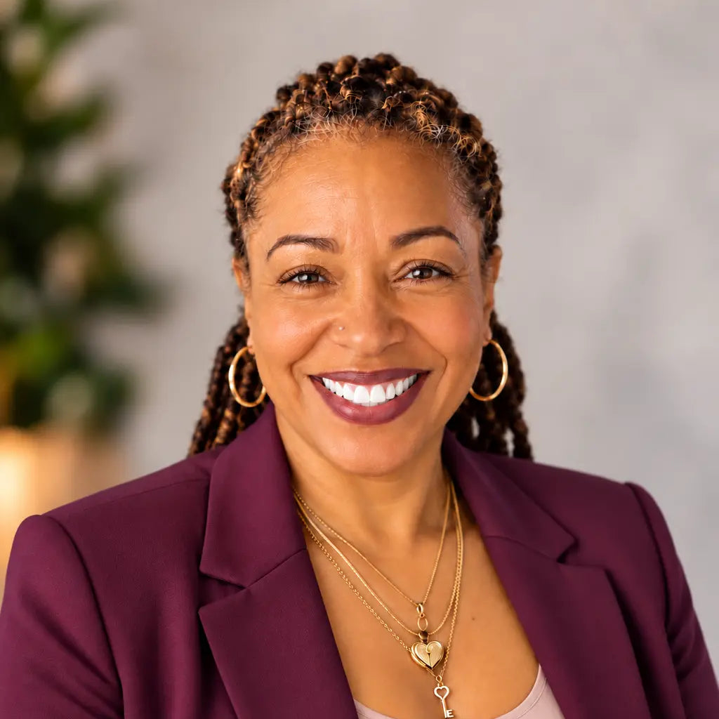 Natasha Peat, MSN, MHA, RN, Registered Nurse and founder of Nurse Calm Aromatherapy™, smiling in a burgundy blazer and pink top in a professional portrait representing the nurse behind the wellness-inspired aromatherapy brand.
