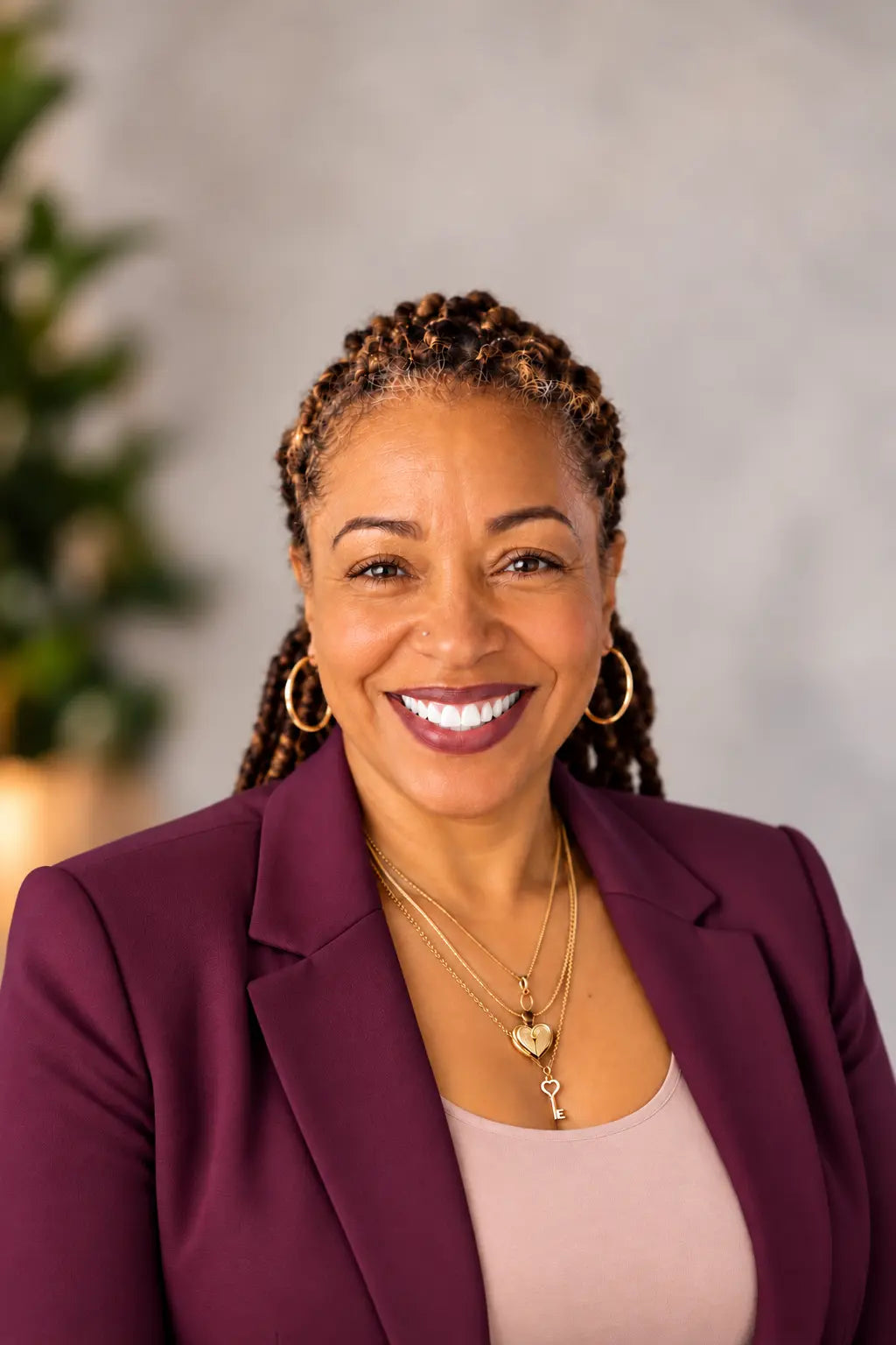 Natasha Peat, MSN, MHA, RN, Registered Nurse and founder of Nurse Calm Aromatherapy™, smiling in a burgundy blazer and pink top in a professional portrait representing the nurse behind the wellness-inspired aromatherapy brand.