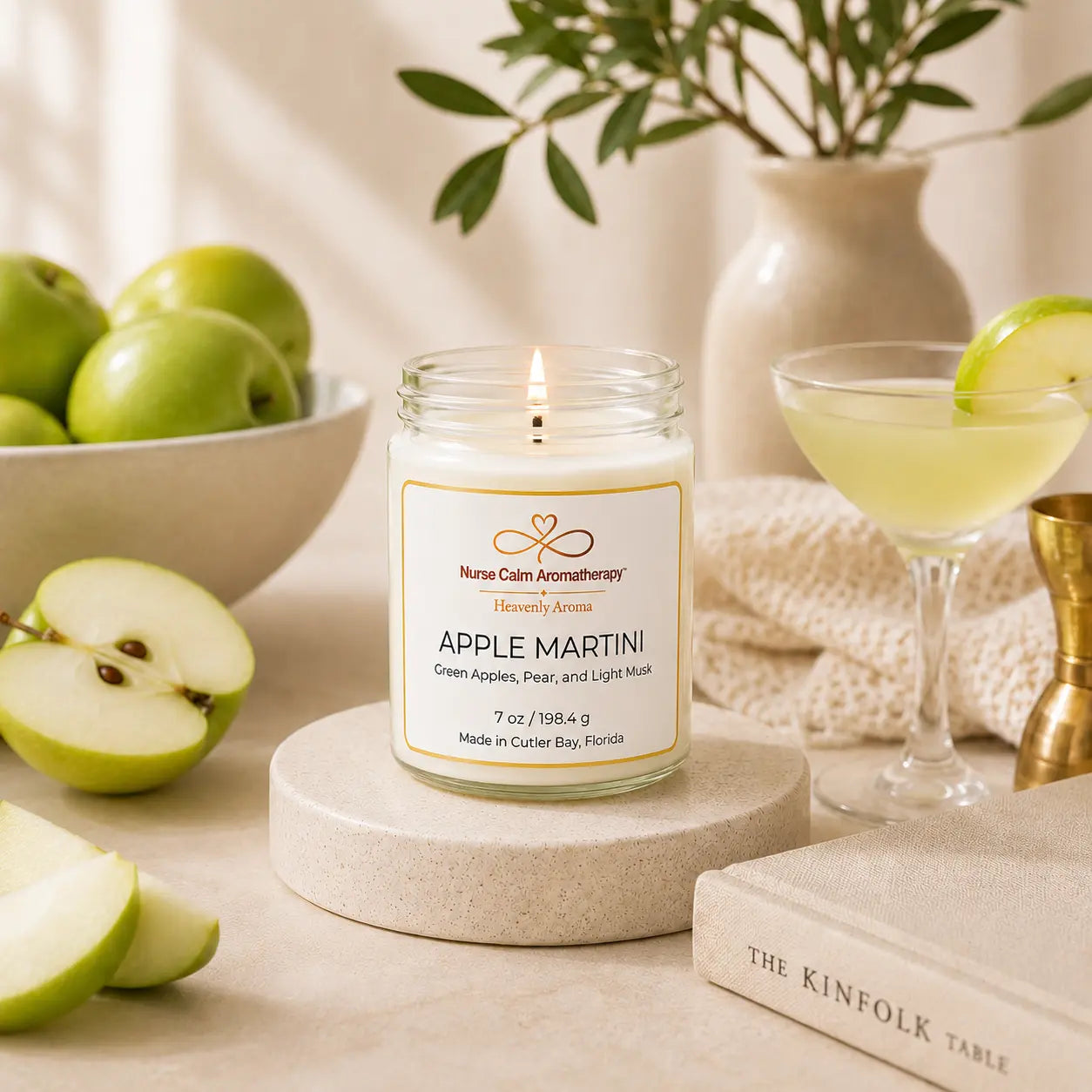 Candle labeled 'Apple Martini' with apples and a cocktail in the background