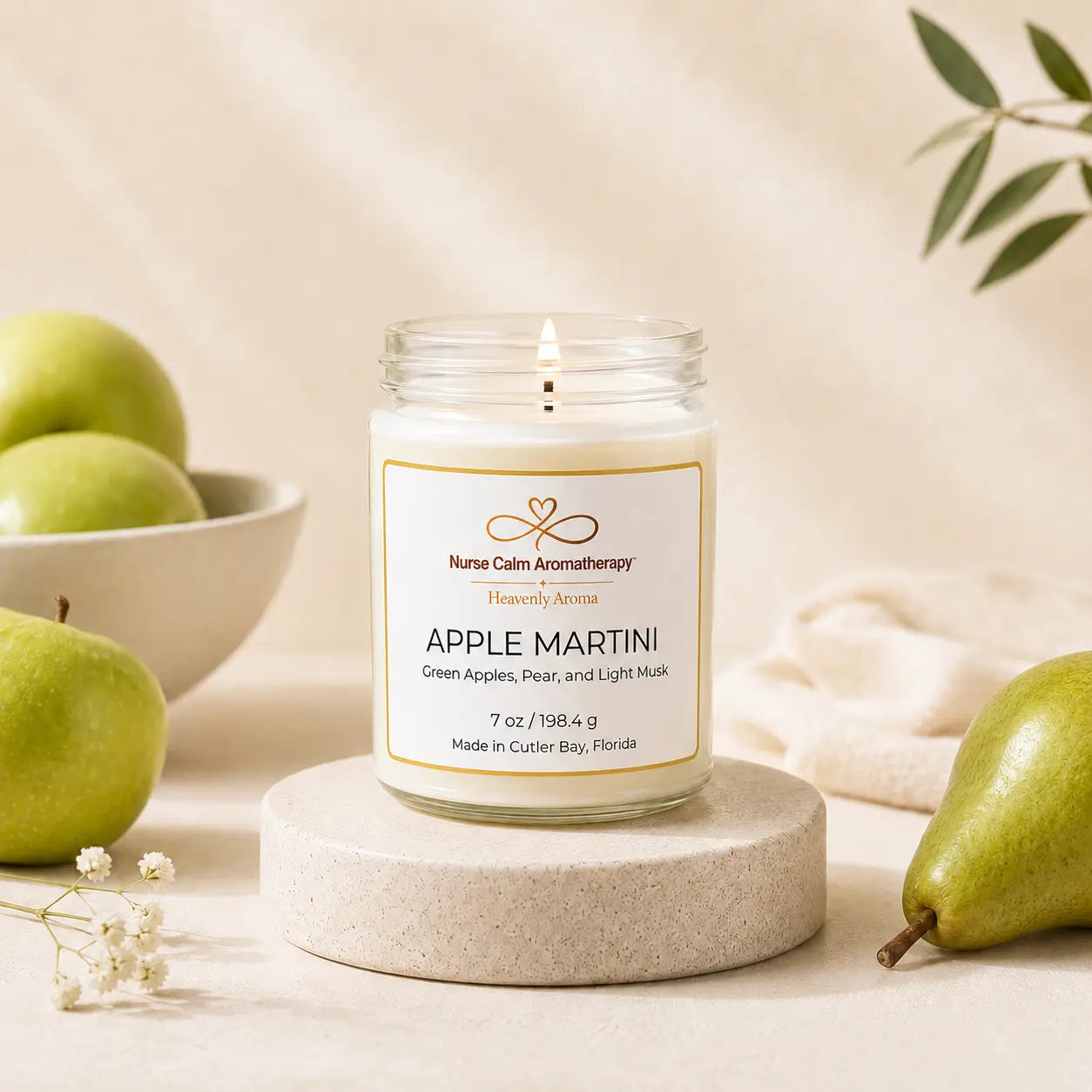 Candle labeled 'Apple Martini' with green apples and pears on a neutral background