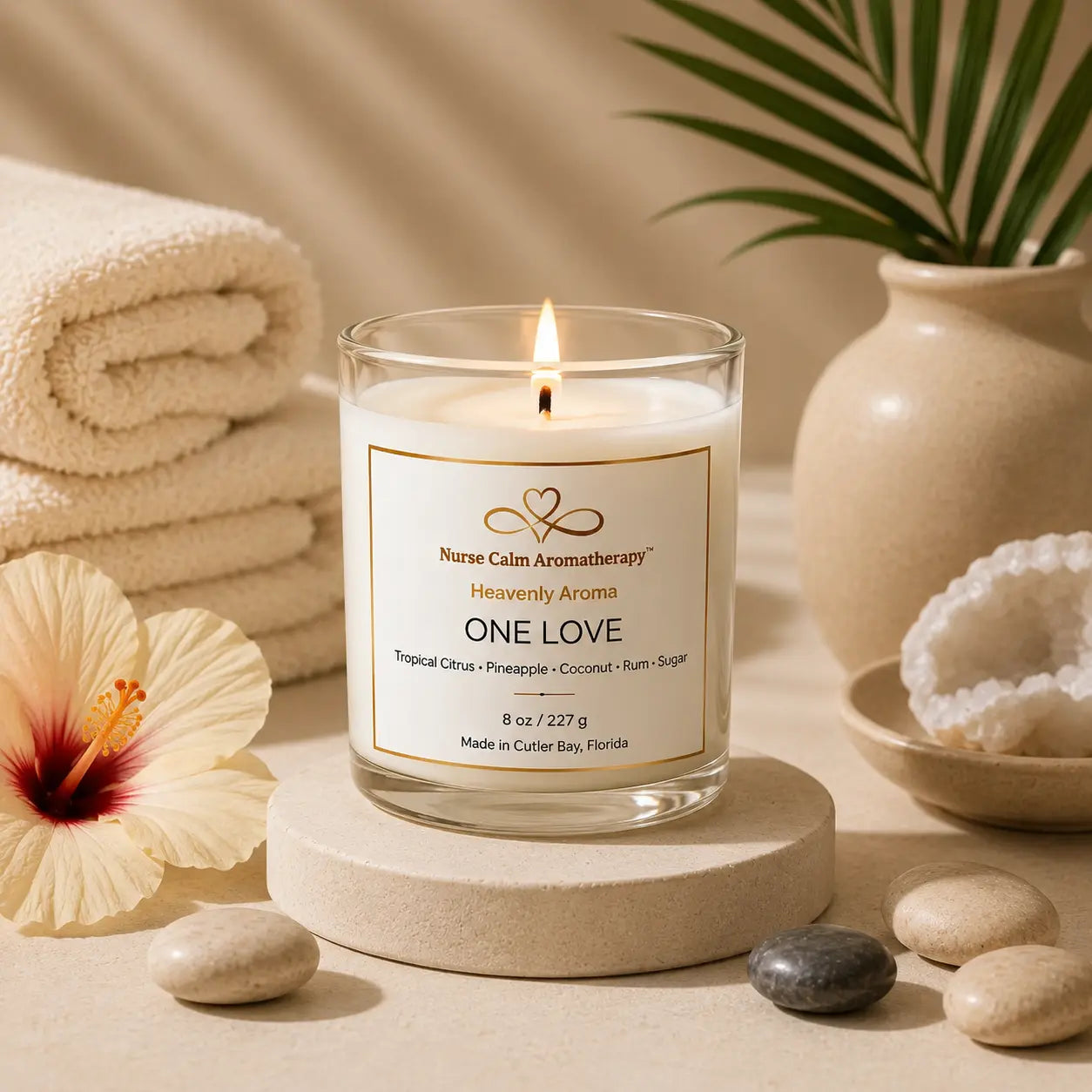 One Love tropical candle burning on cream spa décor