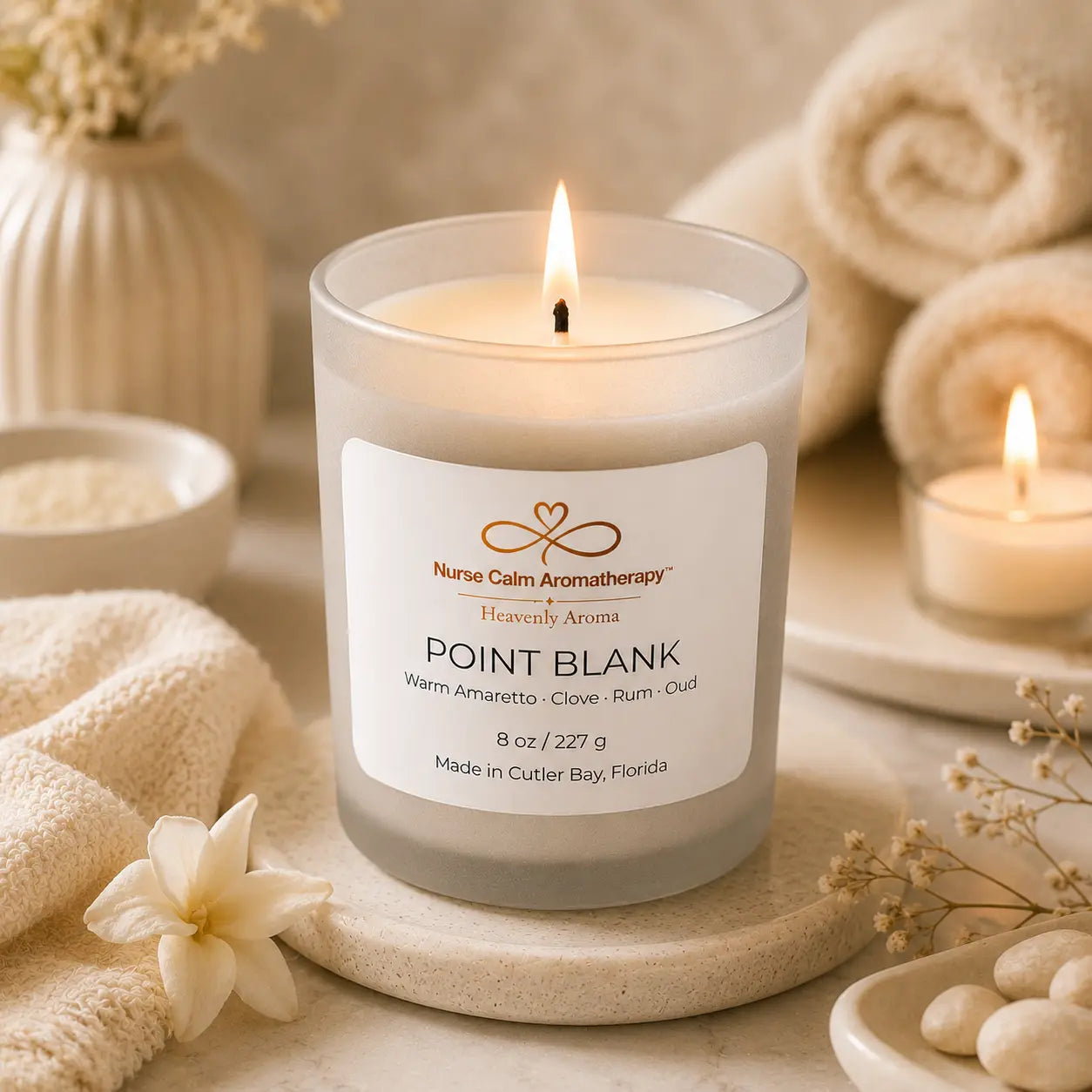 Point Blank candle burning on cream spa décor